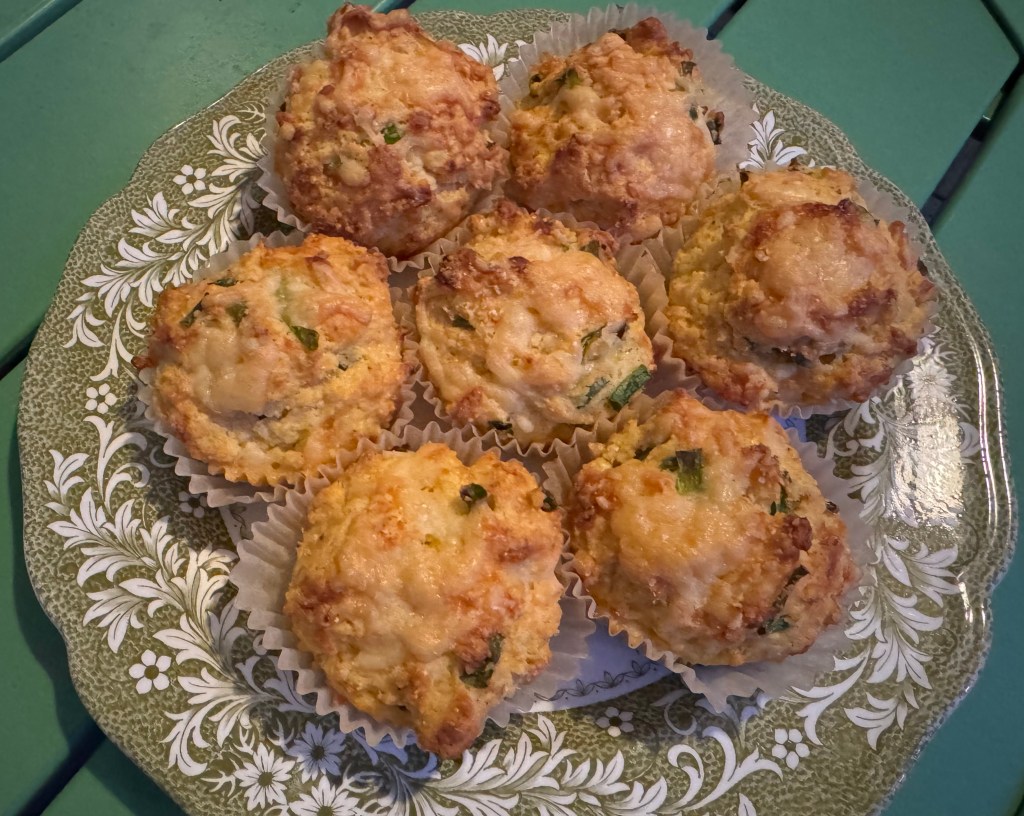 Photo of cheddar cornmeal muffins on a green and white antique plate